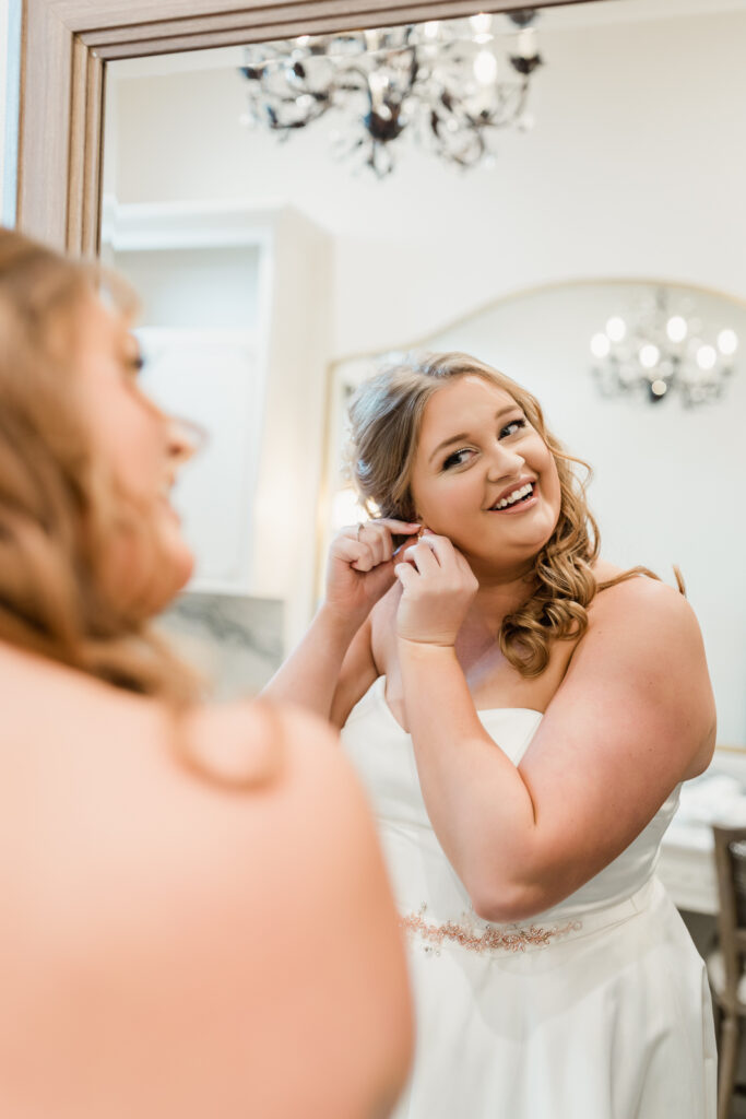 photo of bride putting earrings on