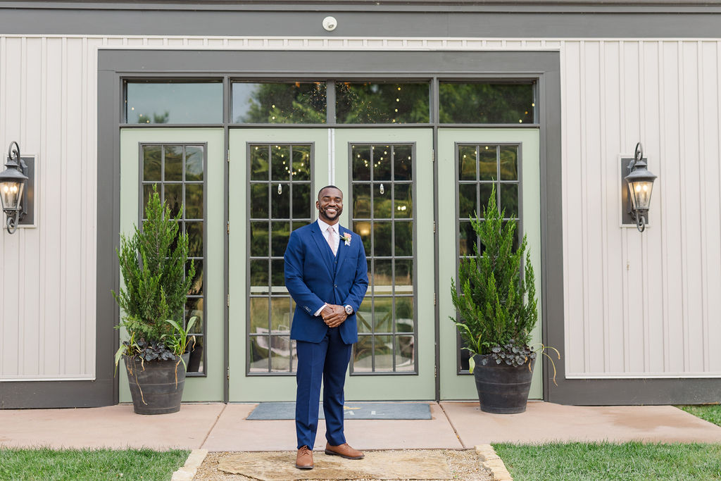 Portrait of groom in front of barn at the marmalade lily