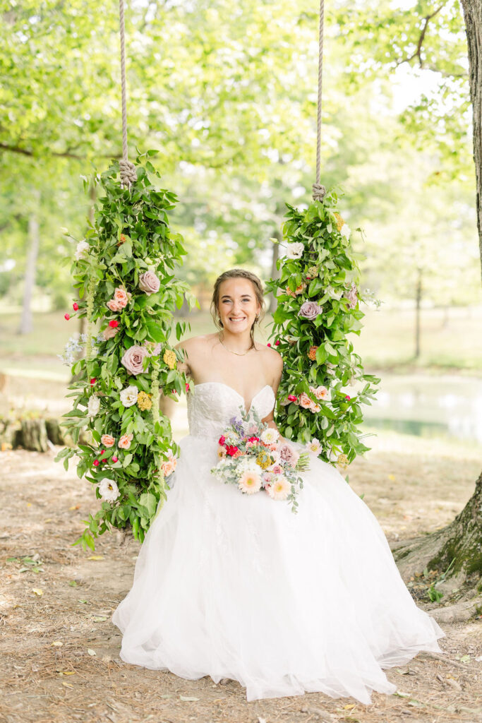 Bride sitting on swing with flowers at The Marmalade Lily