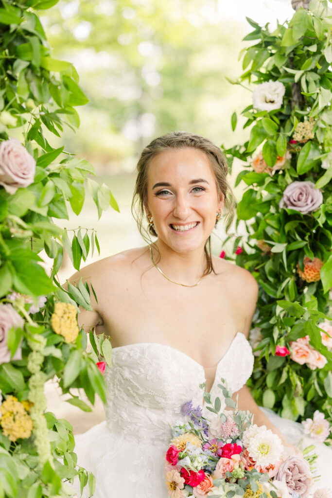 Bride sitting on swing with flowers at The Marmalade Lily